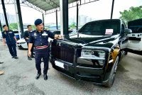 Muhammad Kifli menunjukkan kenderaan mewah disita menerusi Op Luxury.