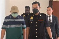 Mohd Rizal (kiri) hadir ke Mahkamah Sesyen Shah Alam pada Selasa.