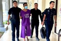 Anggota polis mengawal ketat tertuduh ketika berjalan menuju ke lokap mahkamah. 