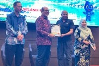 Izham (dua dari kiri) menyampaikan sijil penghargaan kepada salah seorang peserta Bengkel FOR di Shah Alam pada Khamis.