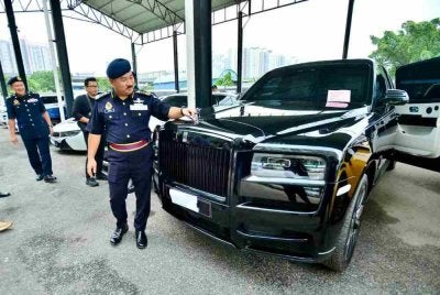 Muhammad Kifli menunjukkan kenderaan mewah disita menerusi Op Luxury.