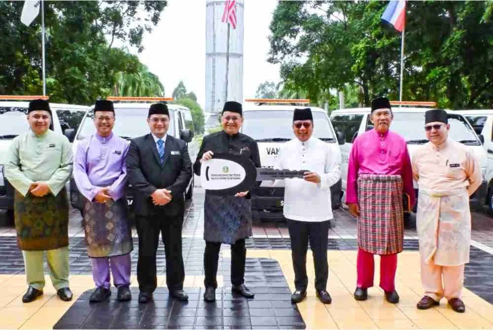 Mohd Arifin (empat dari kiri) menyerahkan replika kunci kepada Isnin (tiga dari kanan) semasa majlis penyerahan van jenazah Muis di Wisma Innoprise, Kota Kinabalu.