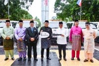 Mohd Arifin (empat dari kiri) menyerahkan replika kunci kepada Isnin (tiga dari kanan) semasa majlis penyerahan van jenazah Muis di Wisma Innoprise, Kota Kinabalu.