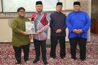 Mohd Ridhwan (dua dari kiri) menyampaikan sumbangan kepada salah seorang penerima.