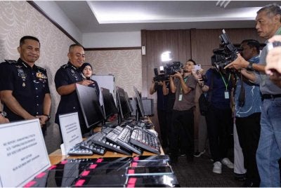 Mohd Alwi (dua dari kiri) menunjukkan barangan yang dirampas ketika sidang akhbar di IPK Perak pada Jumaat.
