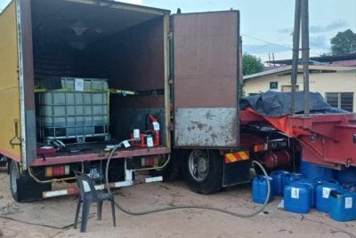 Sebahagian daripada 939 liter minyak diesel serta lori dan peralatan yang dirampas susulan serbuan Ops TIRIS di sebuah lokasi di Kampung Bukit Tunggal di sini pada Khamis.