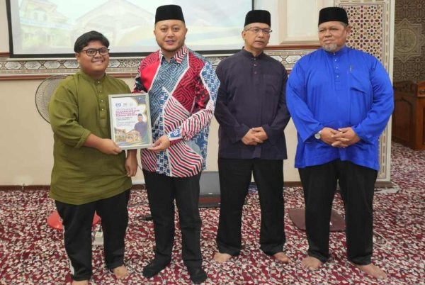 Mohd Ridhwan (dua dari kiri) menyampaikan sumbangan kepada salah seorang penerima.
