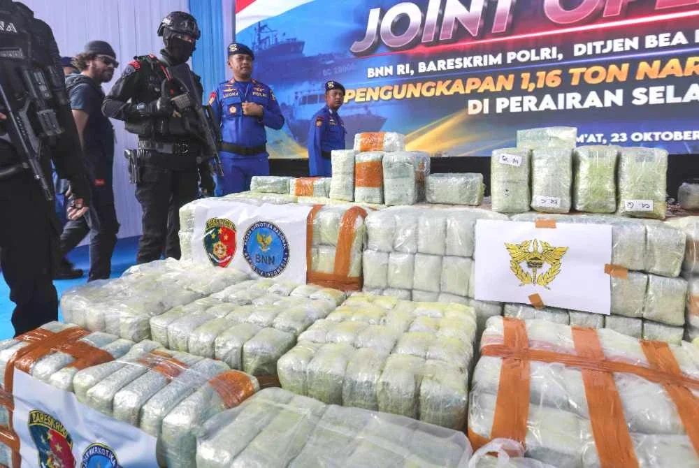Anggota polis Indonesia berkawal di sisi bungkusan dadah yang dirampas daripada kapal tangki MT Global 168. Foto AFP