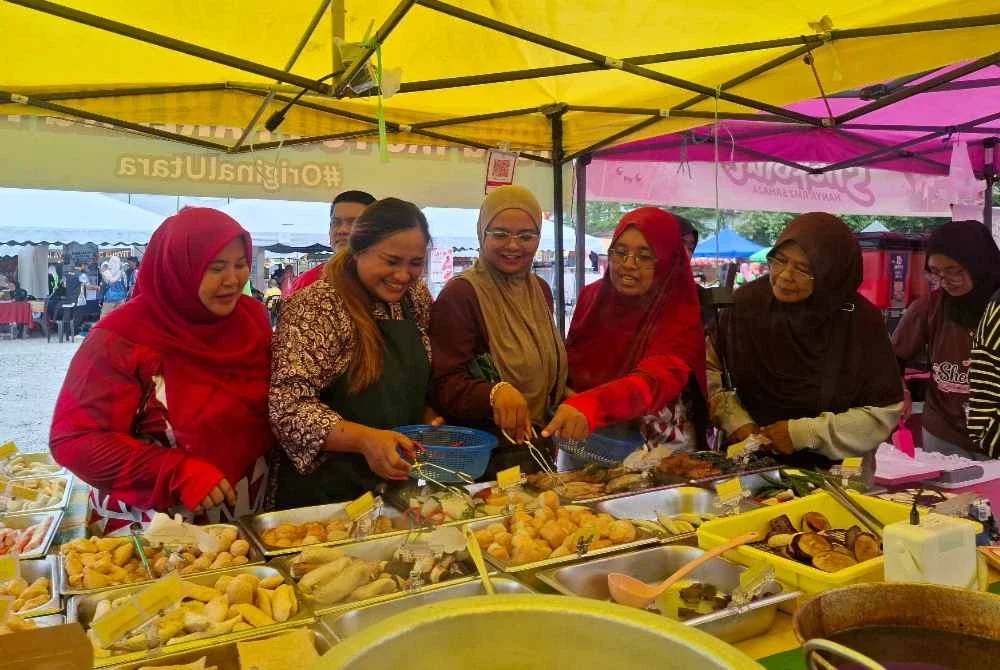 Alfirzamunira (dua dari kanan) ketika meninjau gerai jualan sempena Karnival Penjaja dan Usahawan Bersama Komuniti 2026 di Ipoh pada Sabtu.