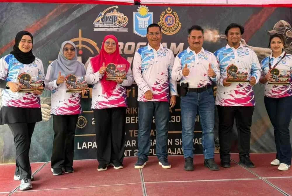 Muhammad Kifli (tiga dari kanan) menyampaikan hadiah kepada peserta acara menembak di Lapang Sasar Shapadu, Presint 20 Putrajaya pada Sabtu.