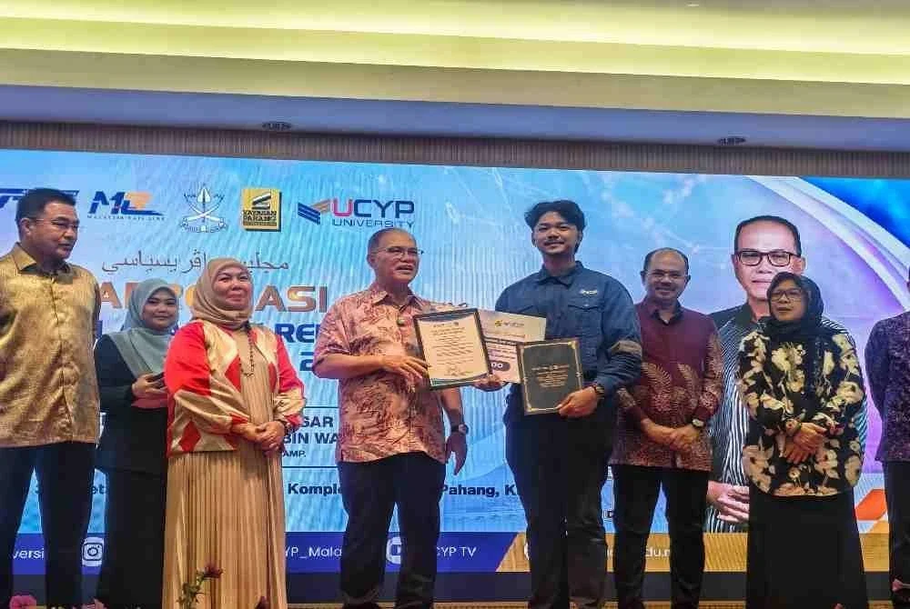 Menteri Besar Pahang, Datuk Seri Wan Rosdy Wan Ismail menyampaikan sijil serta mock up cek Anugerah Pelatih Terbaik kepada Muhammad Adam Hakimi Zulkifli pada Majlis Apresiasi Pelatih Program Latihan Kemahiran Industri East Coast Rail Link (PLKI-ECRL) di Yayasan Pahang 