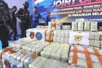 Anggota polis Indonesia berkawal di sisi bungkusan dadah yang dirampas daripada kapal tangki MT Global 168. Foto AFP