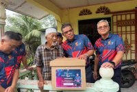 Saifuddin (dua dari kanan) menyerahkan sumbangan kepada penduduk di Kampung Melayu Sedenak, Kulai.