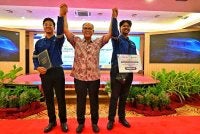 Menteri Besar, Datuk Wan Rosdy Wan Ismail mengangkat tangan Muhammad Adam Hakimi Zulkifli (kanan) dan salah seorang lagi pelatih sebagai tanda syabas dan tahniah atas kejayaan menamatkan latihan teknikal ECRL di China pada Majlis Apresiasi Pelatih PLKI-ECRL.