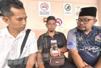 Noor Wandi (tengah) menunjukkan gambar arwah anaknya, Putera Muhaimin yang terkorban dalam nahas di Jalan Johor Bahru-Melaka, Bagan, Batu Pahat.