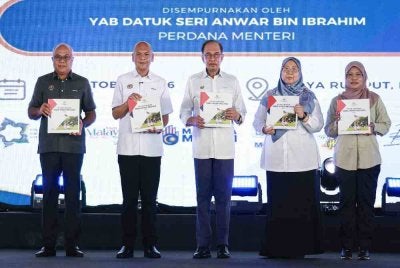 Perdana Menteri, Datuk Seri Anwar Ibrahim menunjukkan buku Pelan Tindakan Sara Hidup Negara 2030 (NCLAP2030) di Stadium Hang Jebat pada Sabtu. Foto Bernama 