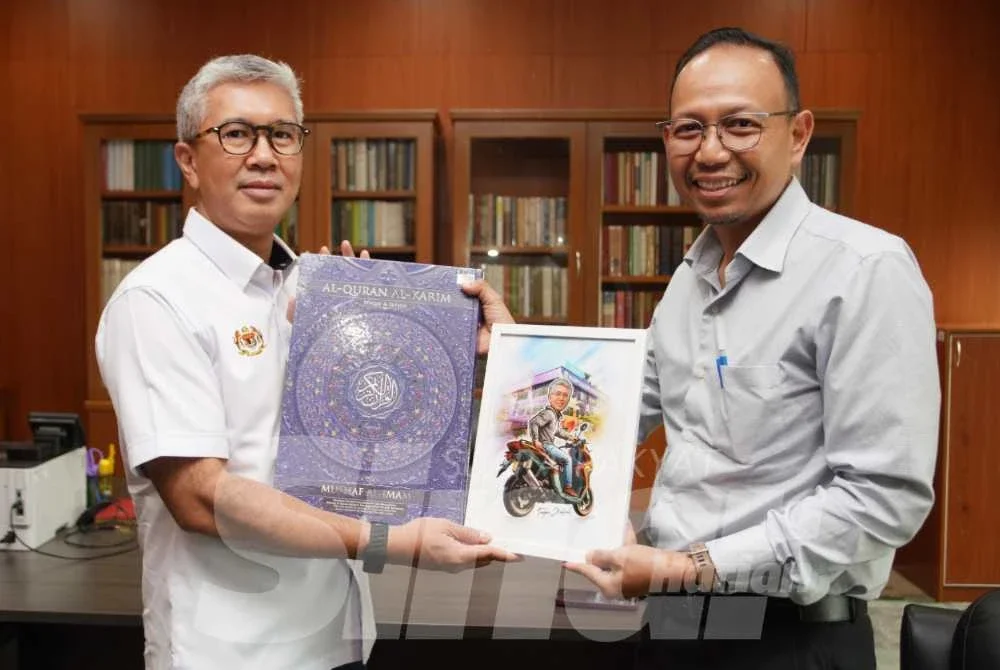 Tengku Zafrul menerima cenderamata daripada Pengarang Berita Sinar Harian, Junhairi Alyasa. Foto: Rosli Talib