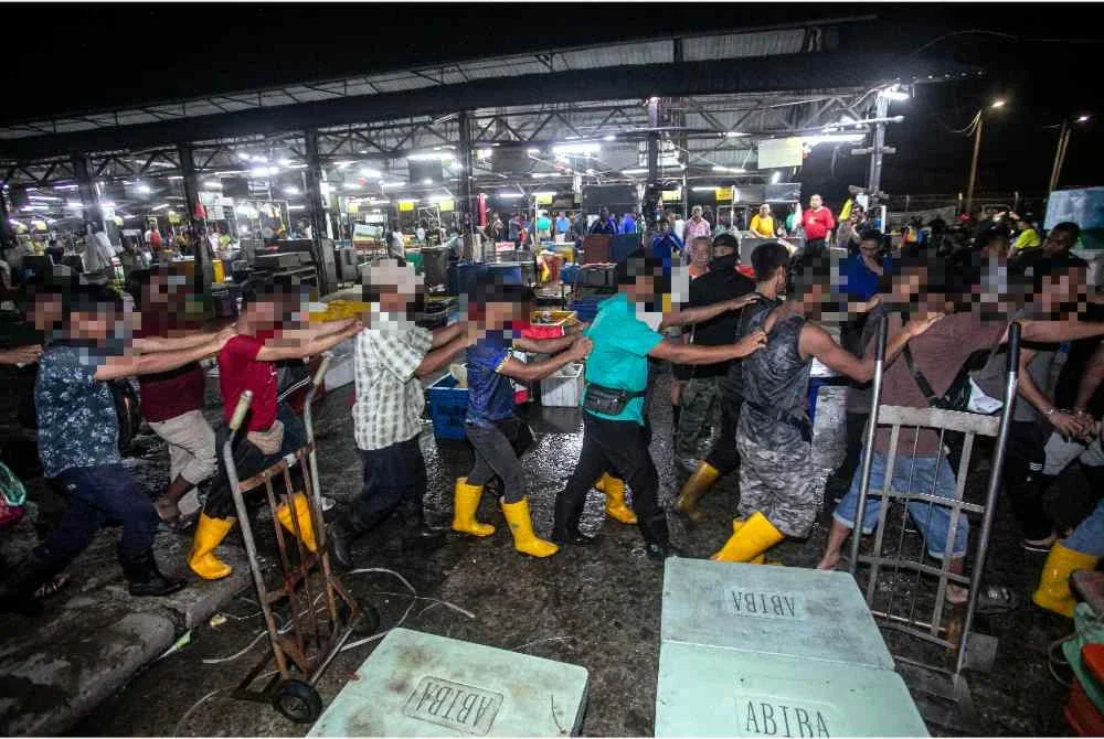 Antara warga asing yang ditahan Jabatan Imigresen Malaysia (JIM) ketika operasi di pasar borong. Foto Bernama 
