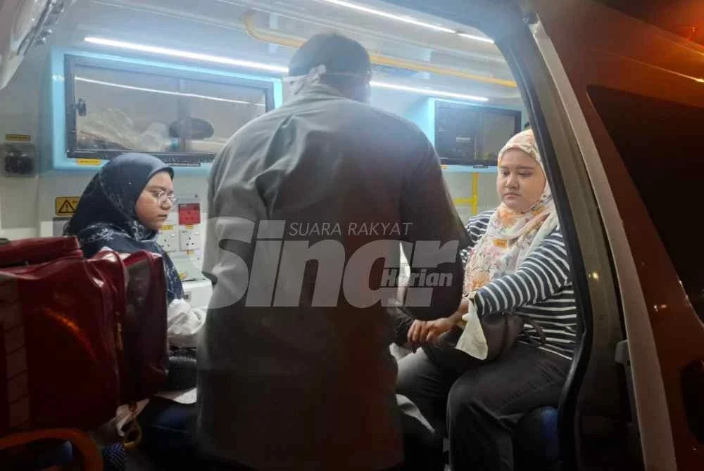 Zahratulhayat (kanan) bersama Nur Afiradina menerima rawatan awal daripada petugas Kementerian Kesihatan Malaysia (KKM) di lokasi kejadian.