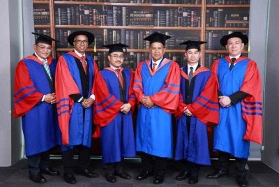 Azmi (tiga dari kanan) dan Saiful Ezral (tiga dari kiri) antara 14 pegawai SPRM yang menerima pengiktirafan bergraduasi Asia e University pada Sabtu. Foto SPRM