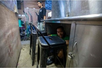 Anggota Jabatan Imigresen Malaysia (JIM) menahan warga asing yang cuba melarikan diri ketika operasi yang dijalankan di pasar borong. Foto Bernama 