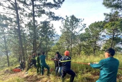 Pihak berkuasa tempatan menarik keluar seorang wanita warga Malaysia yang tergelincir dalam lubang 10 meter di Da Lat, Vietnam. - Agensi