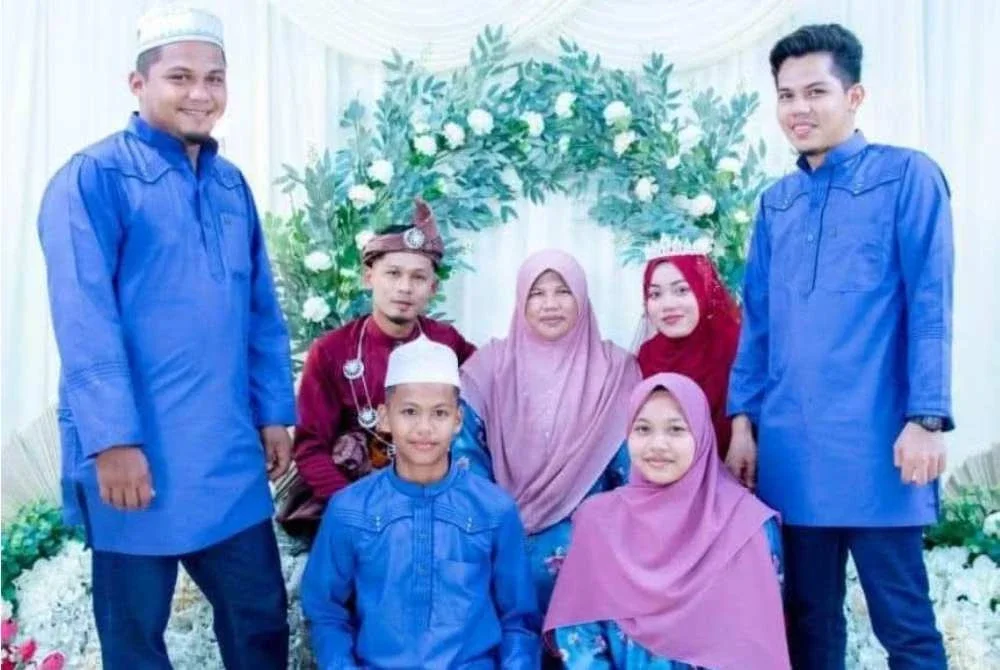 Seedah (tengah, duduk di kerusi) bergambar kenangan bersama anak sulungnya, Mohamad Zulkefli (kiri, berdiri) dan anak bongsu, Muhammad Alif Syukri (kiri,duduk di hadapan) semasa majlis perkahwinan anak perempuan keduanya.