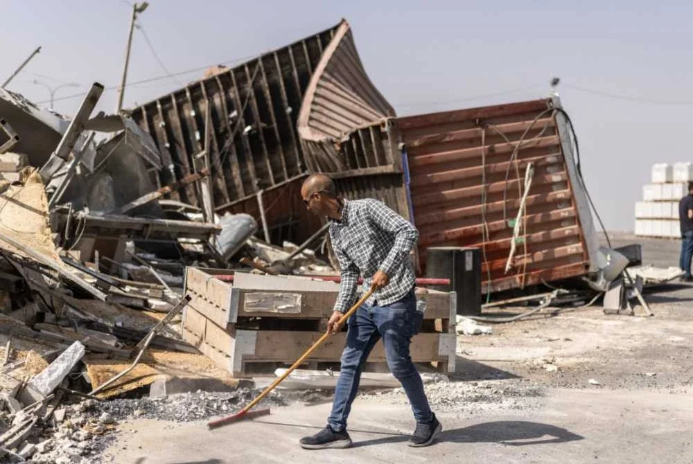 Seorang lelaki Palestin membersihkan sisa runtuhan struktur yang dirobohkan rejim Zionis. Foto AFP