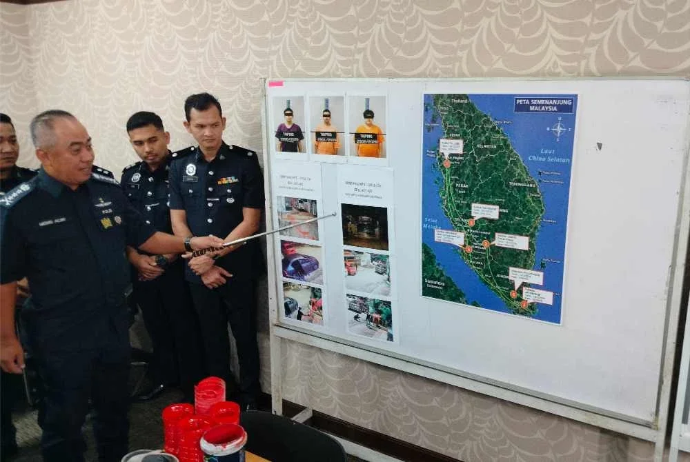 Mohd Alwi (kiri) menunjukkan beberapa gambar dari tangkap layar CCTV memperlihatkan suspek melakukan perbuatan khianat menggunakan cat dan botol berisi petrol yang dibaling ke arah rumah mangsa.