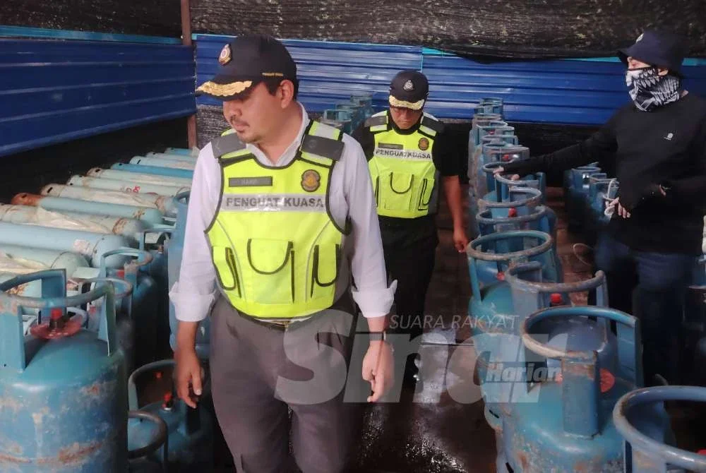 Muhamad Hanif meninjau sebuah stor haram dalam ladang kelapa sawit yang beroperasi bagi melakukan kegiatan pemindahan gas bersubsidi pada Selasa.
