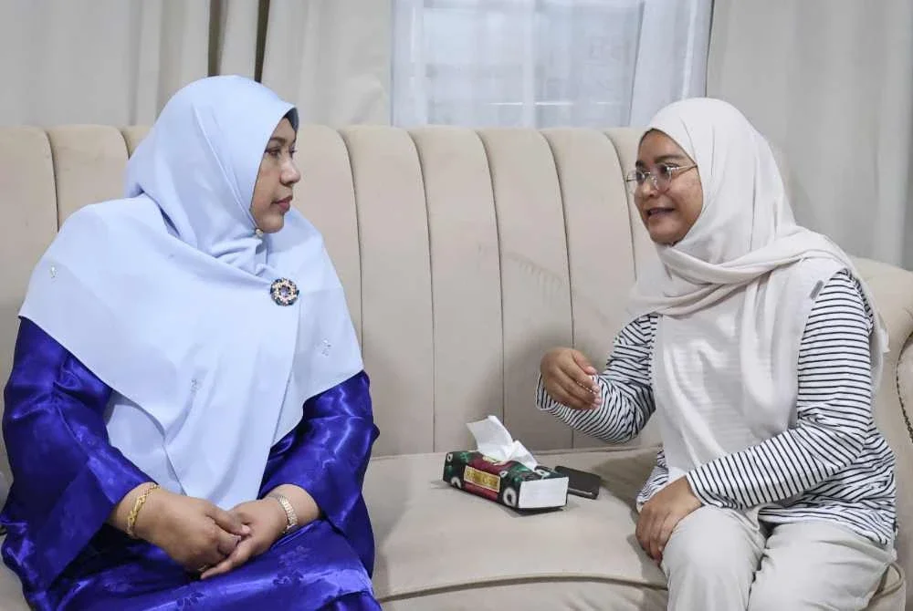Nur-ul Afida (kiri) berbual dengan Nur Afiradina sebelum menyampaikan sumbangan Tabung Kasih@HAWANA x TM di kediamannya di Taman Tasik Semenyih hari ini. Foto: Bernama