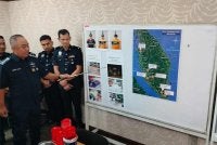 Mohd Alwi (kiri) menunjukkan beberapa gambar dari tangkap layar CCTV memperlihatkan suspek melakukan perbuatan khianat menggunakan cat dan botol berisi petrol yang dibaling ke arah rumah mangsa.