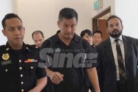 Huann Heng (tengah) bersama peguam dan pegawai SPRM di Mahkamah Sesyen Shah Alam pada Selasa. 