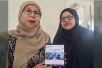 Yatimah (kiri) dan Dr Munirah menunjukkan artikel khas yang ditulis oleh Allahyarham. Foto Sinar Harian.