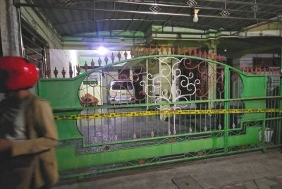 Anggota Polis Madiun Kota memasang garisan polis di rumah DBM yang terletak di Kelurahan Winongo, Kecamatan Manguharjo, Kota Madiun, Jawa Timur pada Ahad. Foto Agensi