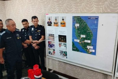 Mohd Alwi (kiri) menunjukkan beberapa gambar dari tangkap layar CCTV memperlihatkan suspek melakukan perbuatan khianat menggunakan cat dan botol berisi petrol yang dibaling ke arah rumah mangsa.