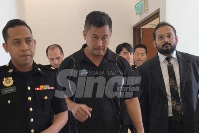 Huann Heng (tengah) bersama peguam dan pegawai SPRM di Mahkamah Sesyen Shah Alam pada Selasa. 