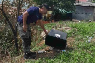 Anggota polis menunjukkan kapak yang digunakan suspek untuk menetak peneroka hingga maut dalam kejadian di Felda Lok Heng Selatan.