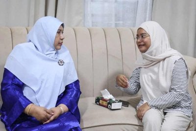 Nur-ul Afida (kiri) berbual dengan Nur Afiradina sebelum menyampaikan sumbangan Tabung Kasih@HAWANA x TM di kediamannya di Taman Tasik Semenyih hari ini. Foto: Bernama