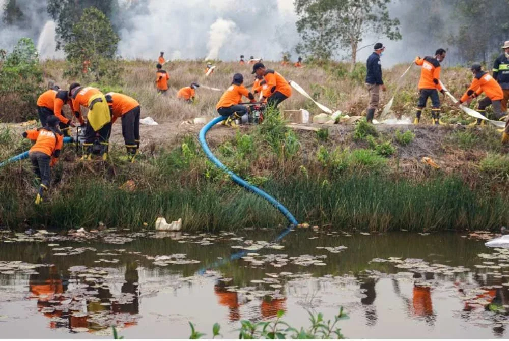 Pasukan bomba mengepam air dari takungan di Barito Kuala, wilayah Kalimantan Selatan. Foto AFP
