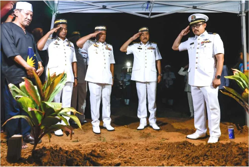 Mohd Zawawi (tiga, kiri) bersama para pegawai dan anggota Maritim memberi penghormatan terakhir ke atas pusara Allahyarham Mohd Roshaimi di Tanah Perkuburan Islam Masjid Tengku Sharafudin. Foto Bernama