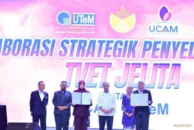 Ahmad Zahid (tiga dari kanan) dan Manndzri (dua dari kiri) menyaksikan sesi pertukaran dokumen kerjasama strategik oleh Massila (kanan) dan wakil pihak UCAM (tiga dari kiri) pada majlis itu.