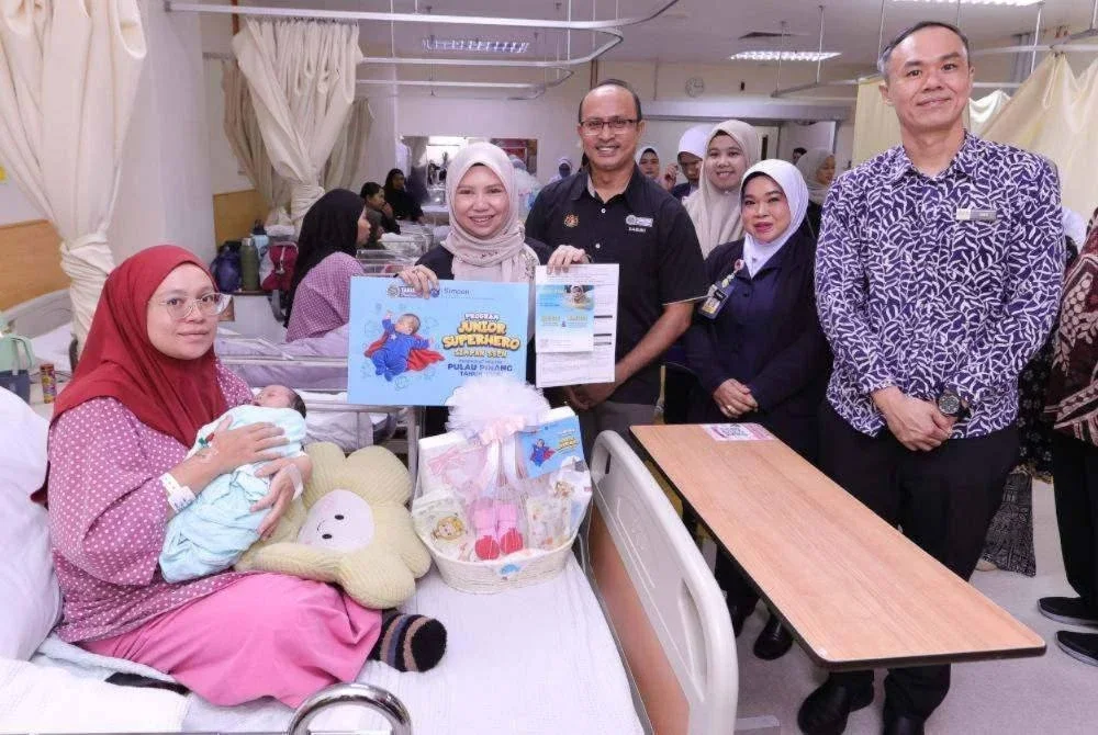 Norliza (empat dari kanan) menyerahkan replika kad sumbangan Program Junior Superhero Simpan SSPN 2026 kepada penerima. 