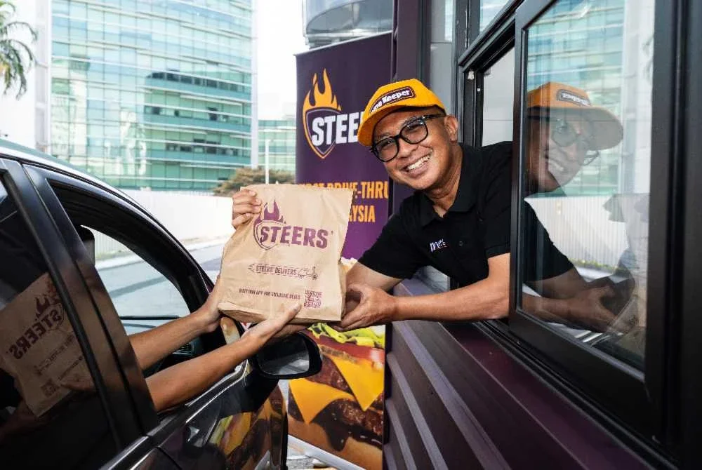 Norazlan menyerahkan pesanan pandu lalu Steers yang pertama kepada pelanggan.