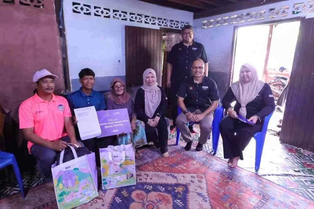 Norliza (duduk, tiga dari kanan) dan Ahmad Dasuki (duduk, dua dari kanan) bergambar bersama penerima BAeK PTPTN (dua dari kiri) ketika sesi penyerahan baru-baru ini.