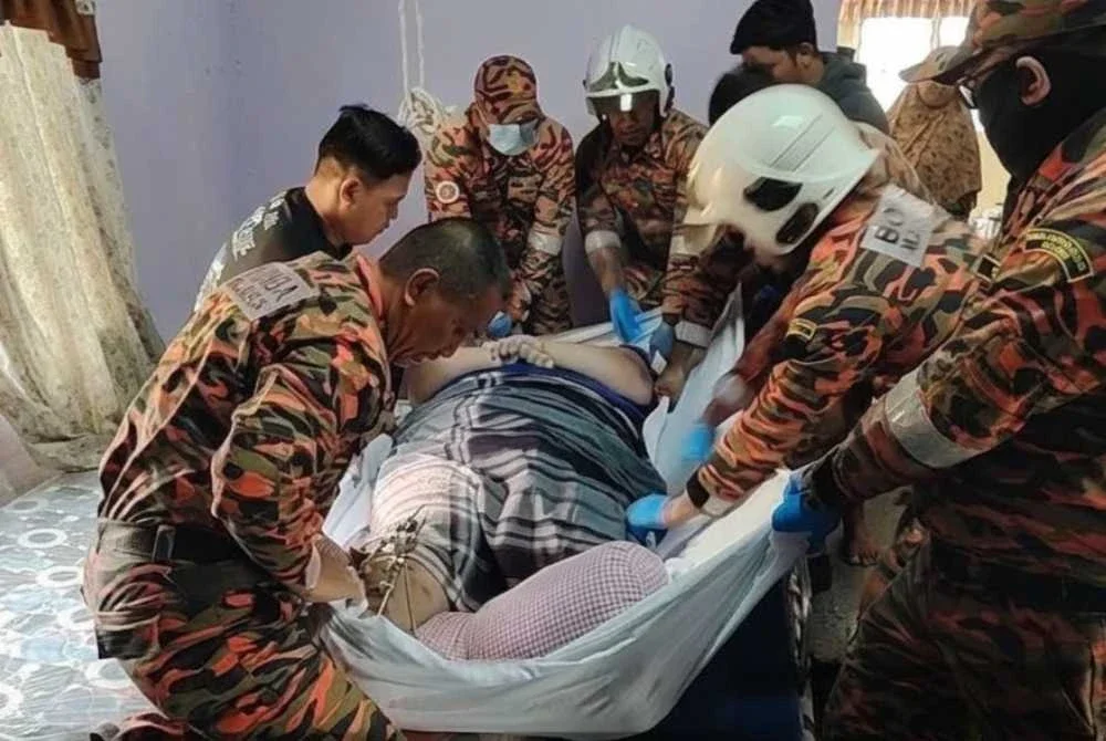 Anggota bomba membantu mengangkat lelaki berkenaan untuk dibawa ke hospital. Foto bomba