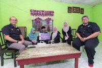 Norliza (tiga dari kanan) bergambar bersama penerima BAeK PTPTN (tiga dari kiri) ketika sesi penyerahan di rumah pelajar di Tasek Gelugor, Pulau Pinang.