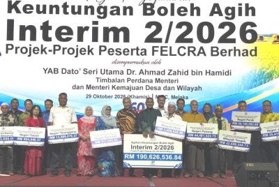 Zahid (tengah) menyerahkan cek cura Agihan Keuntungan Interim 2/226 Projek- Projek Peserta FELCRA Berhad pada Khamis