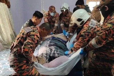 Anggota bomba membantu mengangkat lelaki berkenaan untuk dibawa ke hospital. Foto bomba