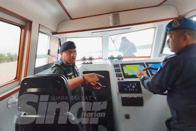 Mohd Yusoff (kiri) melakukan tinjauan di perairan Sungai Kelantan di Tumpat dan Kota Bharu yang dipercayai menjadi laluan baharu penyeludupan PATI ke negara ini. 